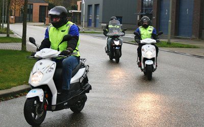Bromfietsles op de weg met instructeur van Autorijschool Theuns