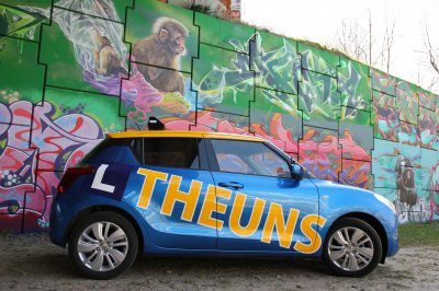 Blauwe lesauto van Autorijschool Theuns met geel daklichtbord